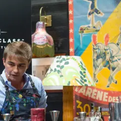 Bartender prepara cocktail difficili con un'atmosfera da circo.