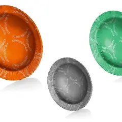 Tre capsule di caffè: arancione, verde e grigia. Alcuni studi suggeriscono che le cialde o capsule cancerogene potrebbero essere un rischio.