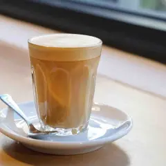 Un bicchiere di caffè latte con schiuma cremosa, pronto per essere gustato. Ecco come si fa un caffè latte perfetto.