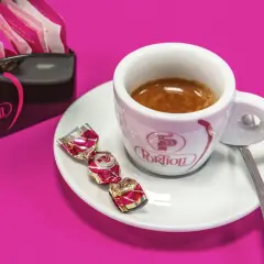 Tazzina di caffè espresso con dolcetti e zuccherini. Per gustare al meglio il tuo caffè, scopri come conservare il caffè in grani.