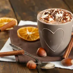 Una tazza di cioccolata calda con panna e cannella, un'ottima alternativa per chi cerca cosa bere al posto del caffè.