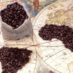 Chicchi di caffè su una mappa antica, che evocano il viaggio e la scoperta di chi ha inventato il caffè.