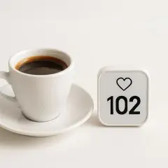 Tazza di caffè nero accanto a un contatore di like con 102. Un promemoria che il caffè e il cortisolo possono influenzare il nostro benessere.