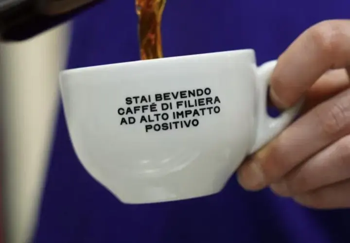 Tazza bianca con scritta "Stai bevendo caffè di filiera ad alto impatto positivo". Un caffè speciale che fa bene.