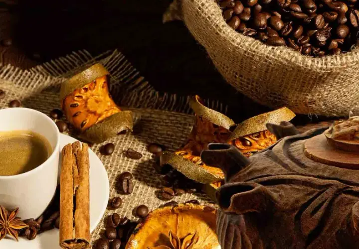 Tazza di caffè fumante, chicchi tostati, cannella e spezie. Una grolla ricetta per un momento di puro piacere.