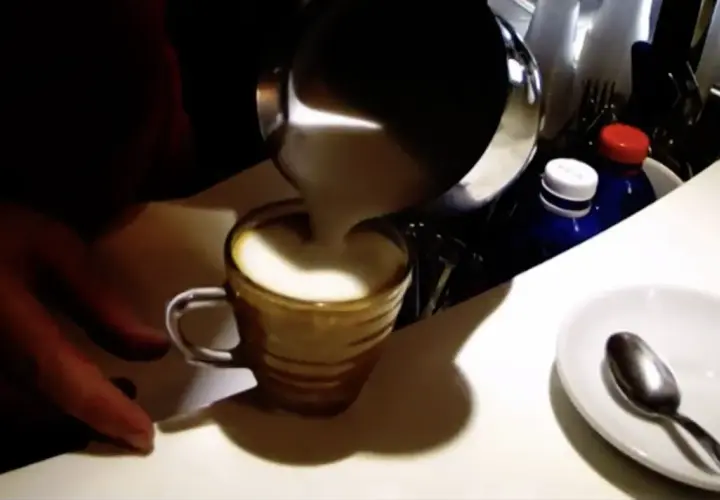Preparazione di un espressino freddo pugliese: schiuma di latte versata in una tazzina.