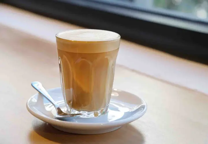 Un bicchiere di caffè latte con schiuma cremosa, pronto per essere gustato. Ecco come si fa un caffè latte perfetto.