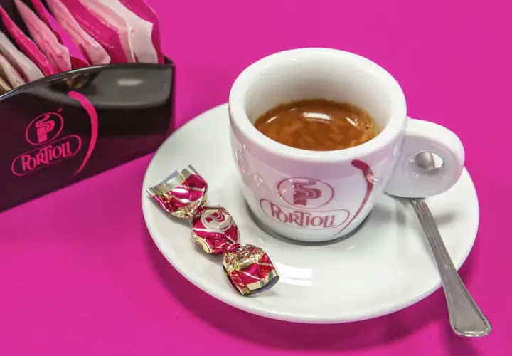 Tazzina di caffè espresso con dolcetti e zuccherini. Per gustare al meglio il tuo caffè, scopri come conservare il caffè in grani.