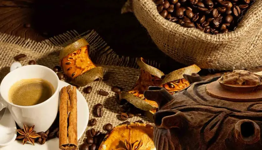 Tazza di caffè fumante, chicchi tostati, cannella e spezie. Una grolla ricetta per un momento di puro piacere.