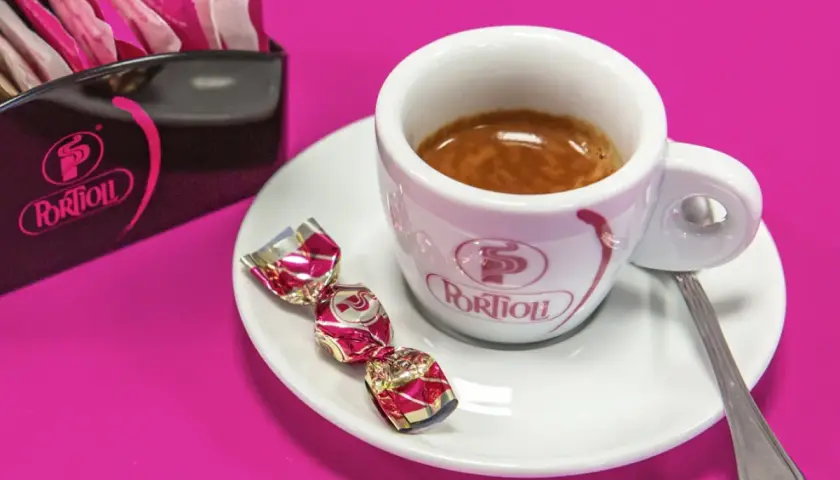 Tazzina di caffè espresso con dolcetti e zuccherini. Per gustare al meglio il tuo caffè, scopri come conservare il caffè in grani.