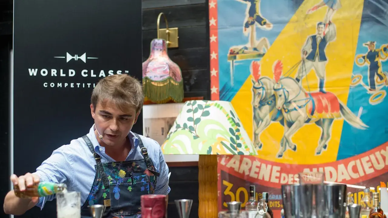 Bartender prepara cocktail difficili con un'atmosfera da circo.