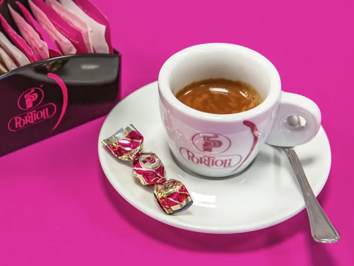 Tazzina di caffè espresso con dolcetti e zuccherini. Per gustare al meglio il tuo caffè, scopri come conservare il caffè in grani.