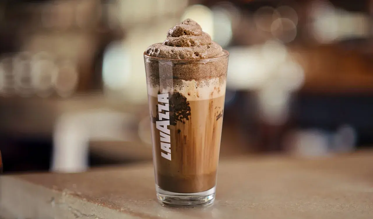 Un bicchiere di Lavazza con un delizioso mocha freddo, coronato da una schiuma cremosa.