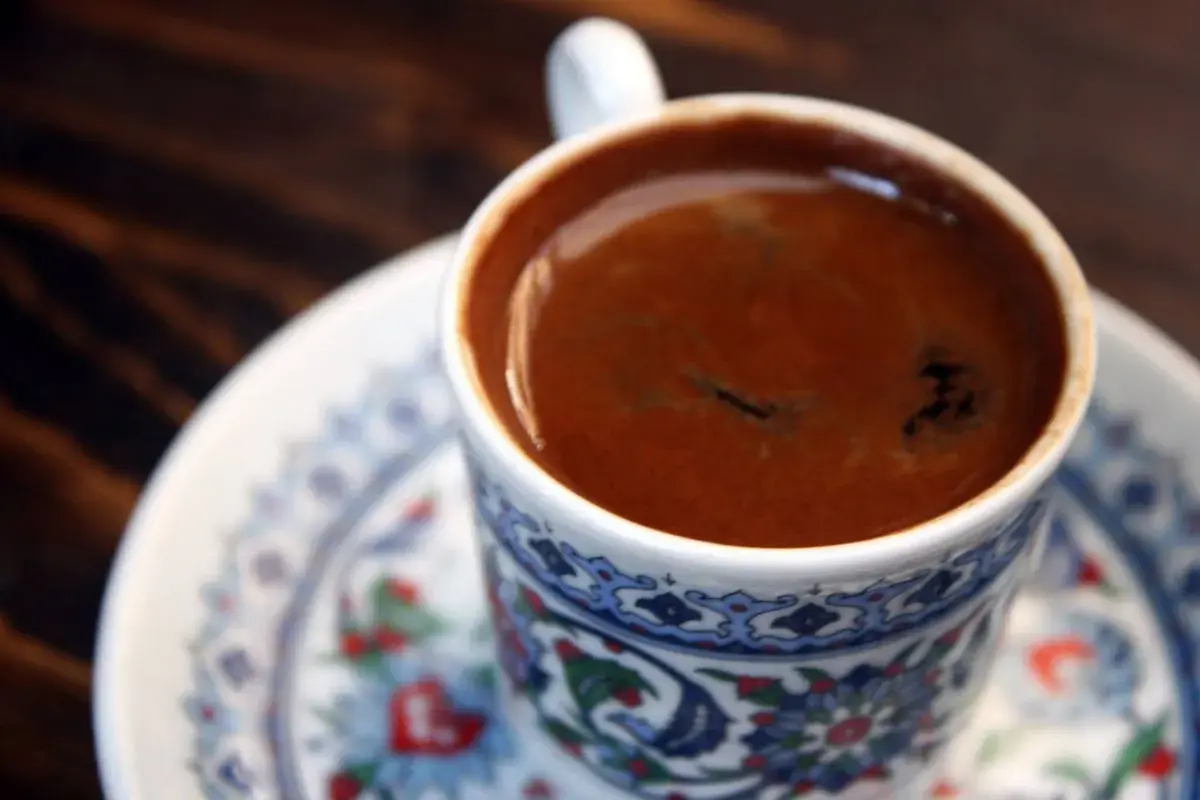 Caffè turco fumante in una tazza decorata, pronto per essere gustato. Scopri come fare il caffè turco senza cezve.