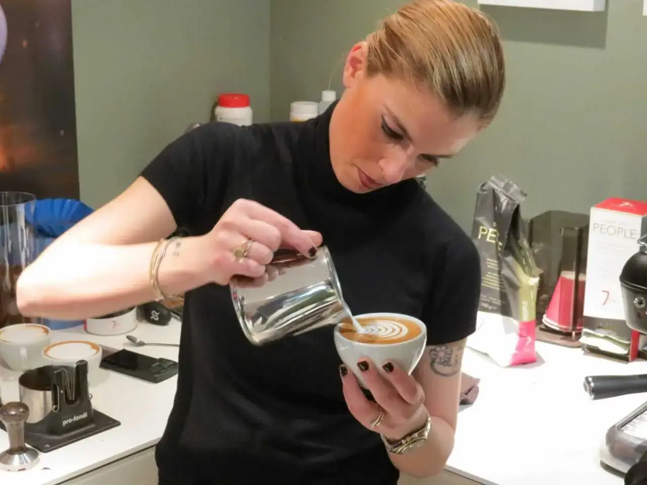 Chiara Bergonzi crea un disegno latte art con maestria, versando il latte montato in una tazza di caff&egrave;.