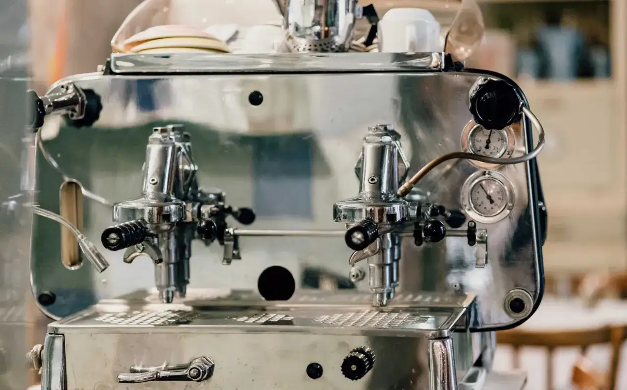 Macchina da caff&egrave; espresso cromata, con manopole nere e manometri. Ricorda chi ha inventato il caff&egrave; espresso.