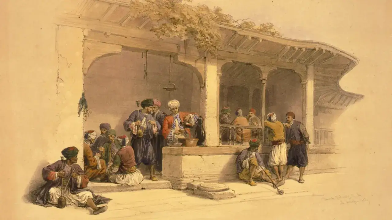 Uomini in abiti tradizionali si riuniscono sotto un portico, forse discutendo di chi ha inventato il caffè, mentre uno serve bevande.
