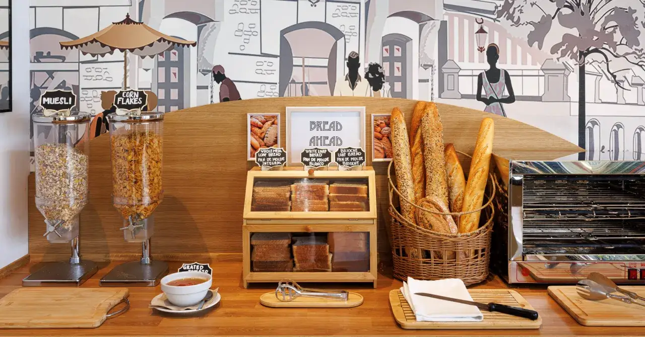 Un buffet per una ricca colazione continentale: cereali, pane fresco, baguette e marmellata.